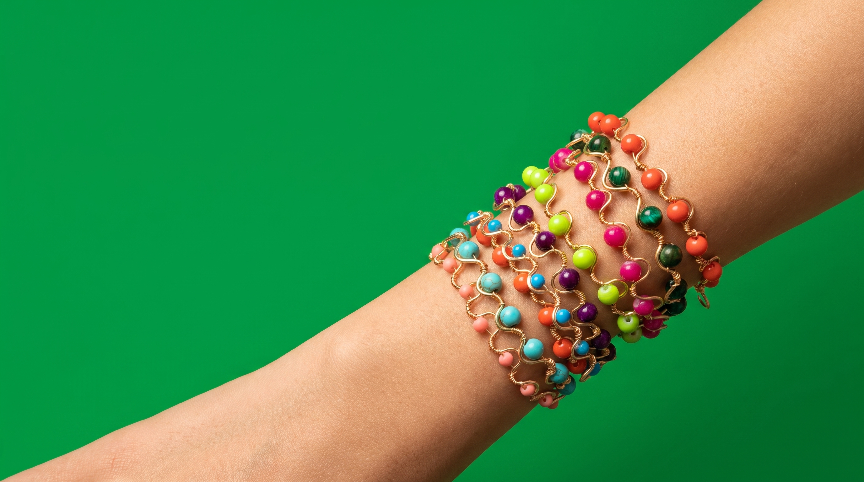 A stack of colorful Wave bracelets worn on the wrist